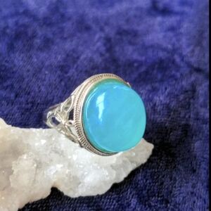 Silver dome shaped ring with large aqua blue insert, adjustable size